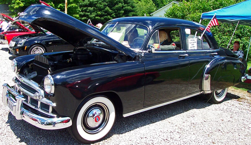 an old fashioned car with it's hood open