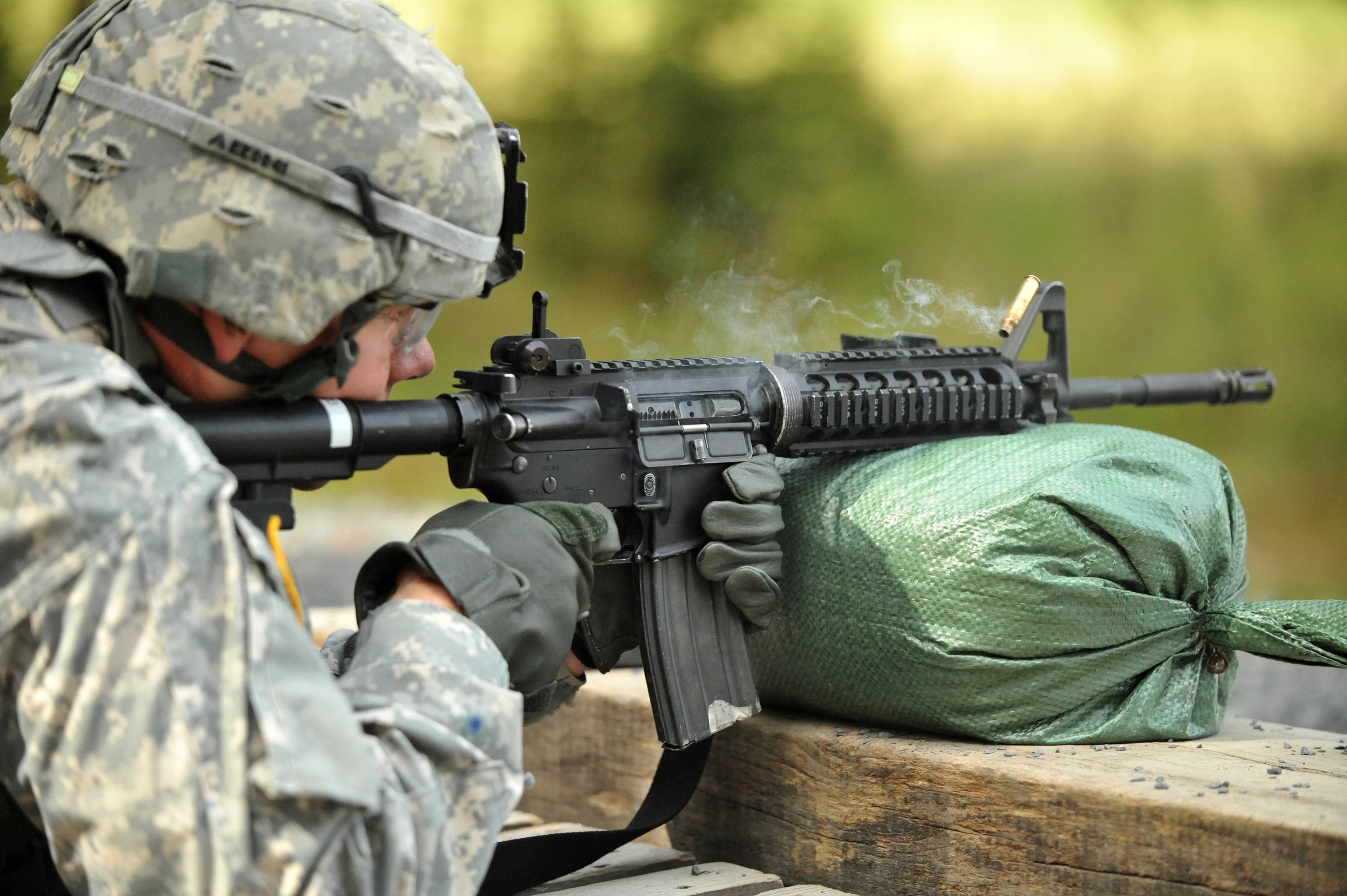 a soldier looks at a gun from a bench