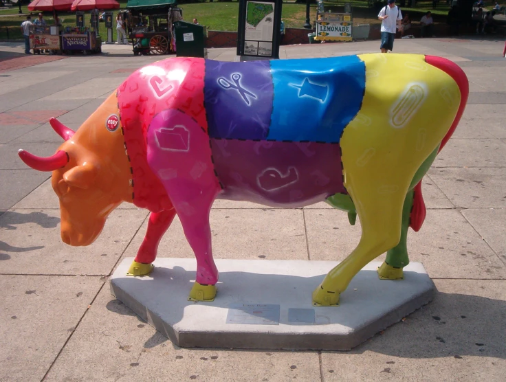 a large cow statue sitting on a sidewalk