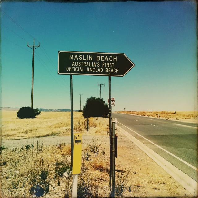 a street sign next to the side of a desert road