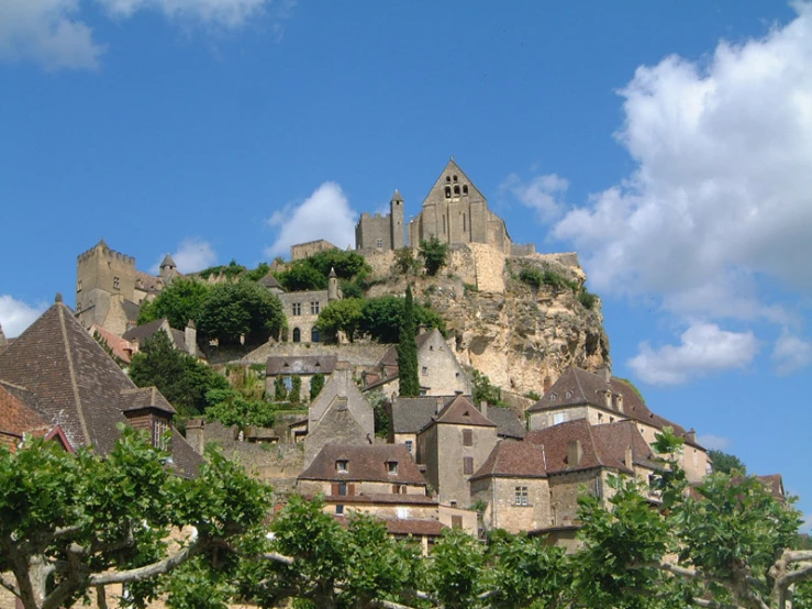 castle - like structures on top of a hill surrounded by trees