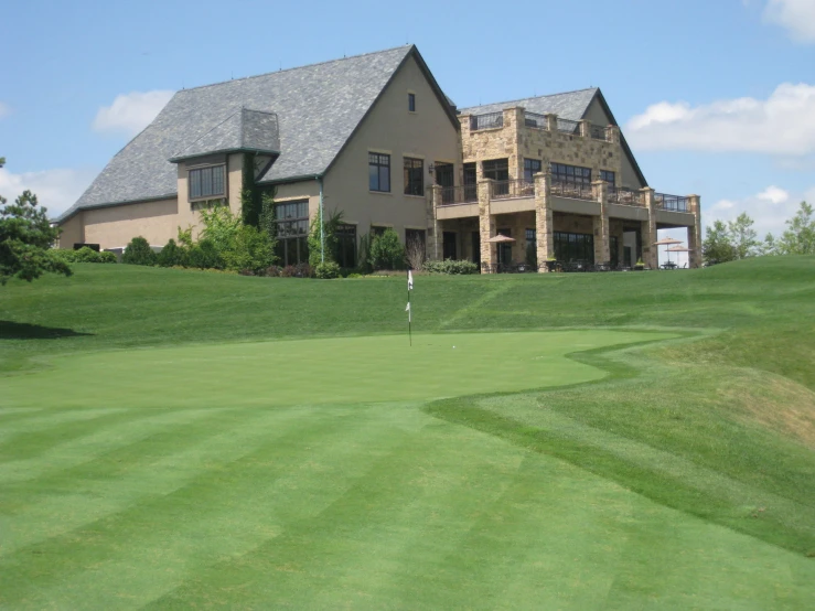 the beautiful house is located on top of a hill overlooking the golf green