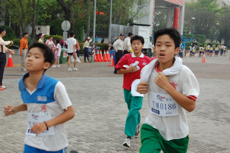 boys running on a path while some are watching