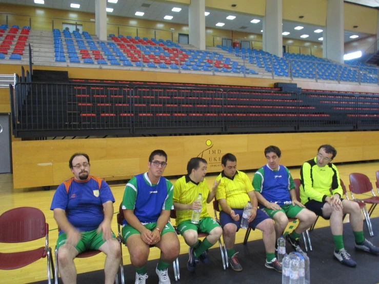 a group of young men sitting on seats in a gymnasium