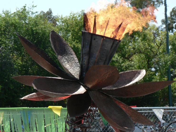 a metal large flower sculpture sitting on top of a table