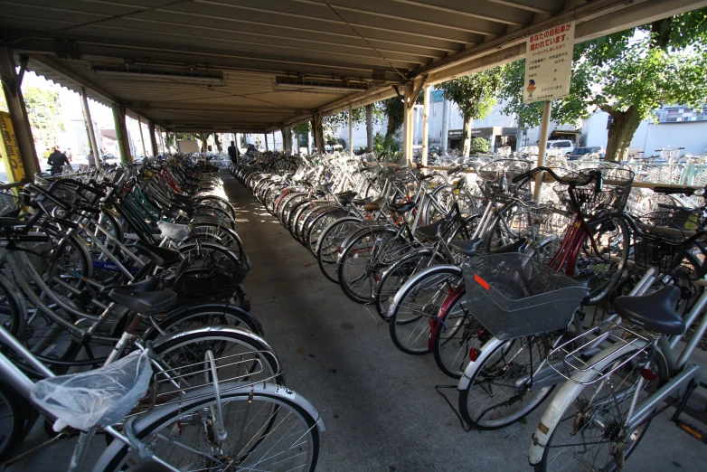 a row of bicycles parked underneath a covered parking garage