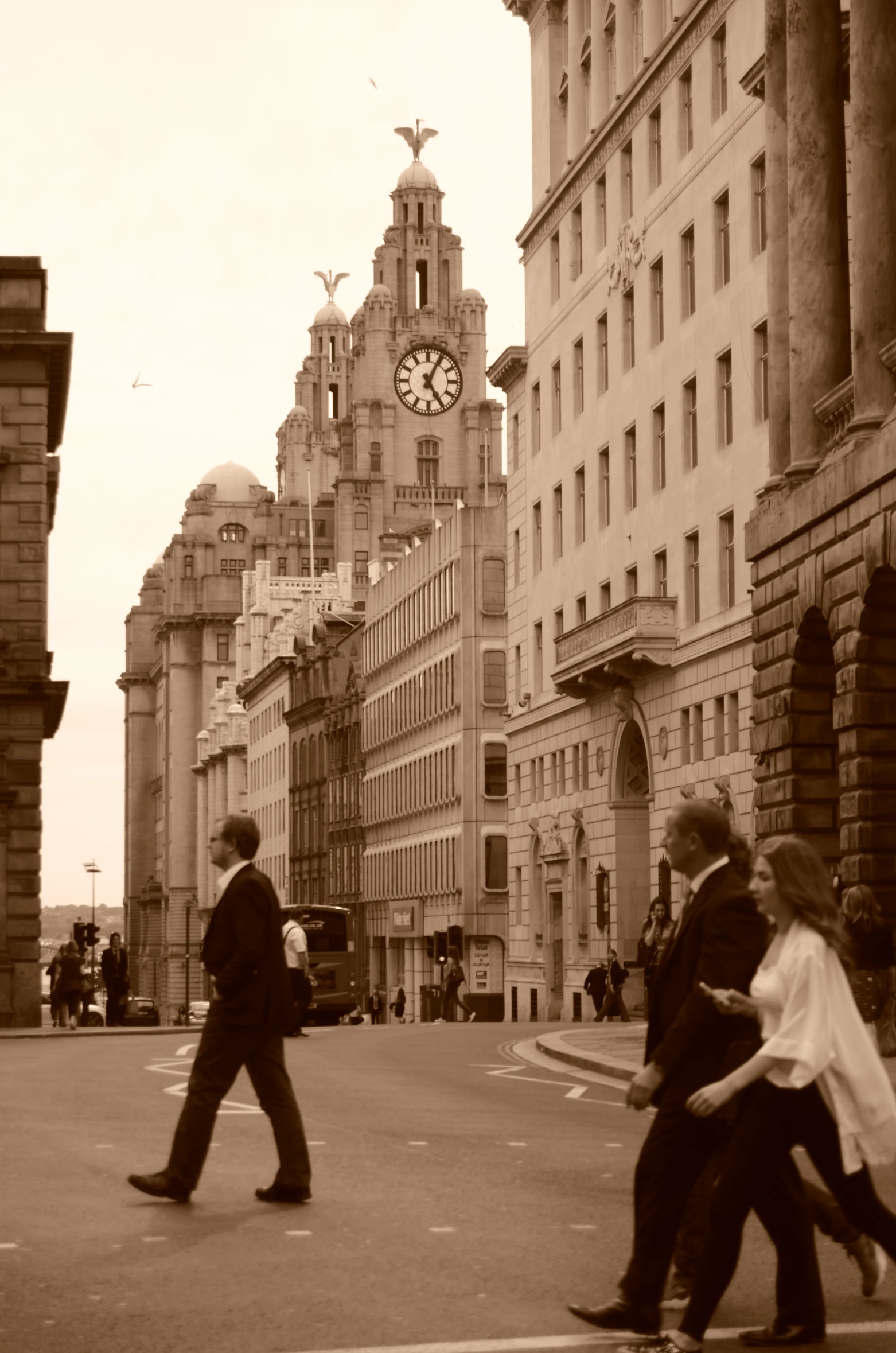 a couple of people walking on a street with buildings in the background