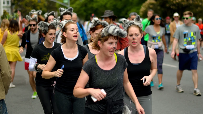 a group of women are running a street