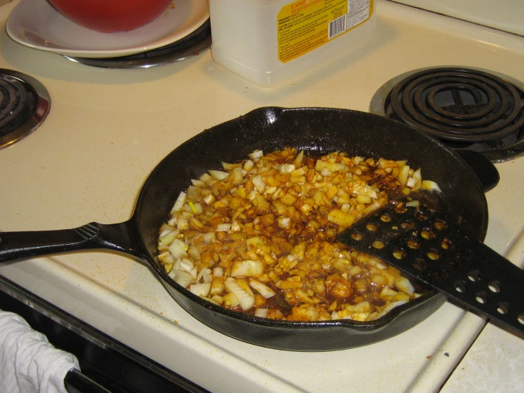 a frying pan full of chopped onions on a stove top