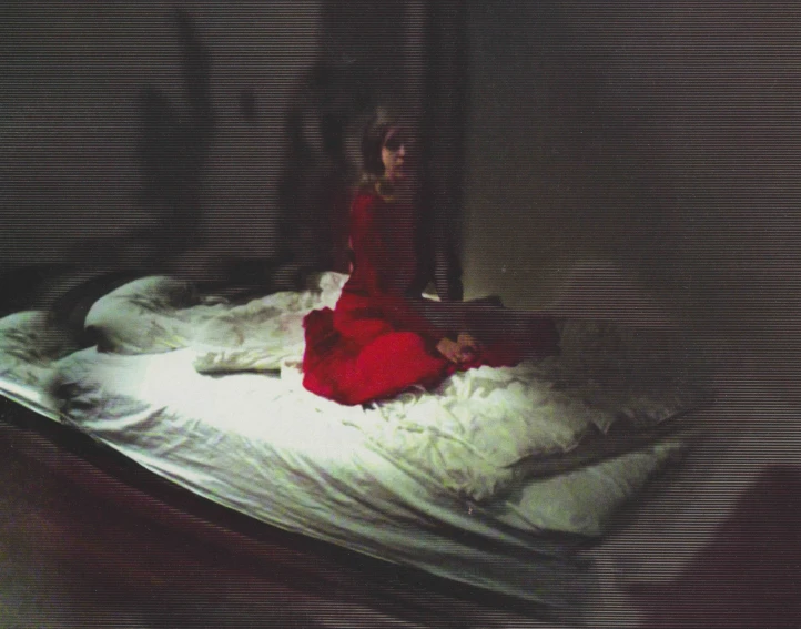 a woman in red and a white dress lying on a pillow