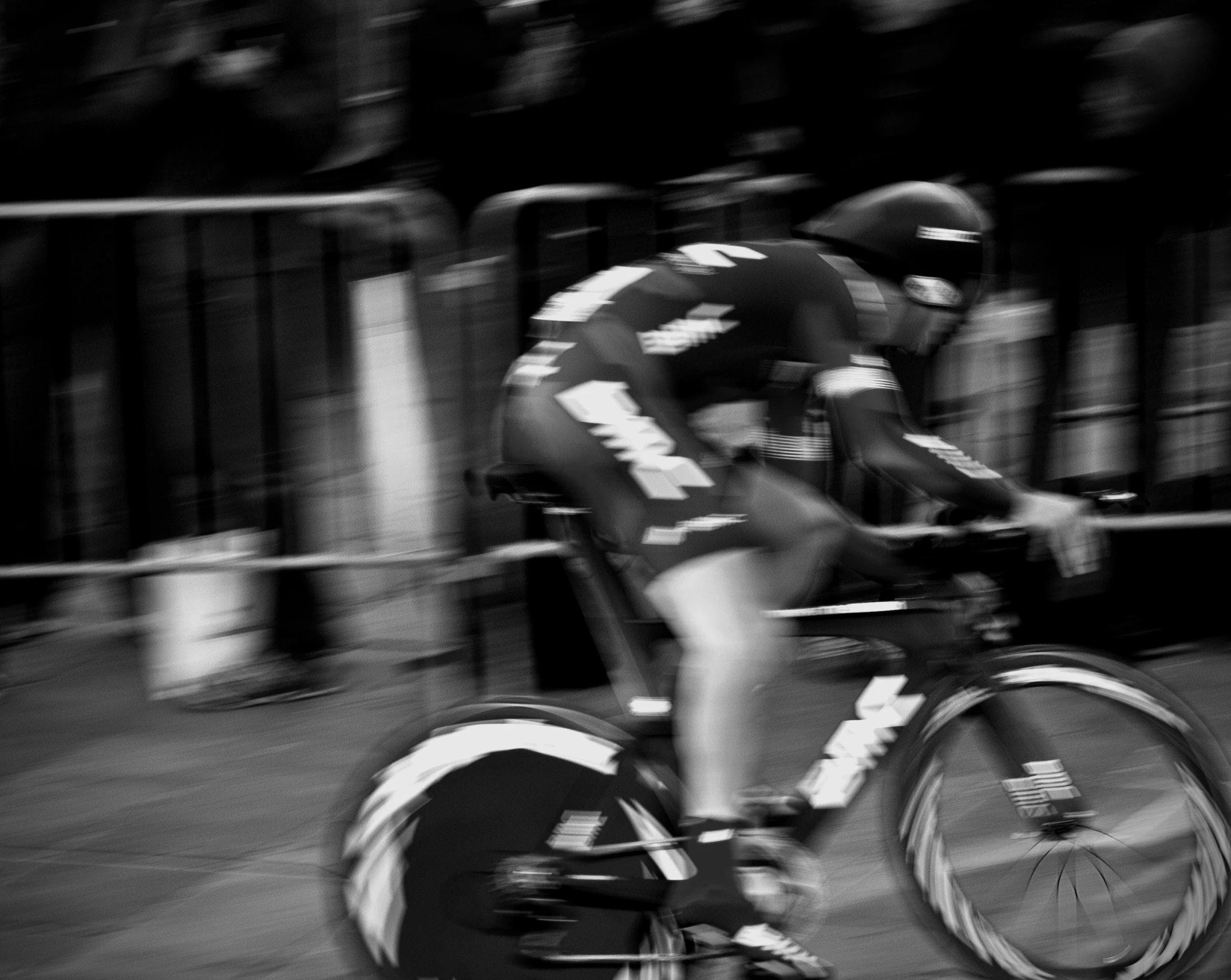 black and white image of a bicyclist passing by