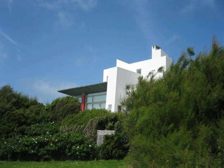 a large white house sits on top of a hill