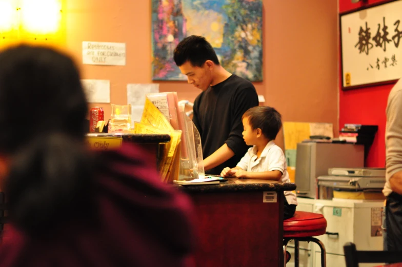 a man standing at a counter behind children