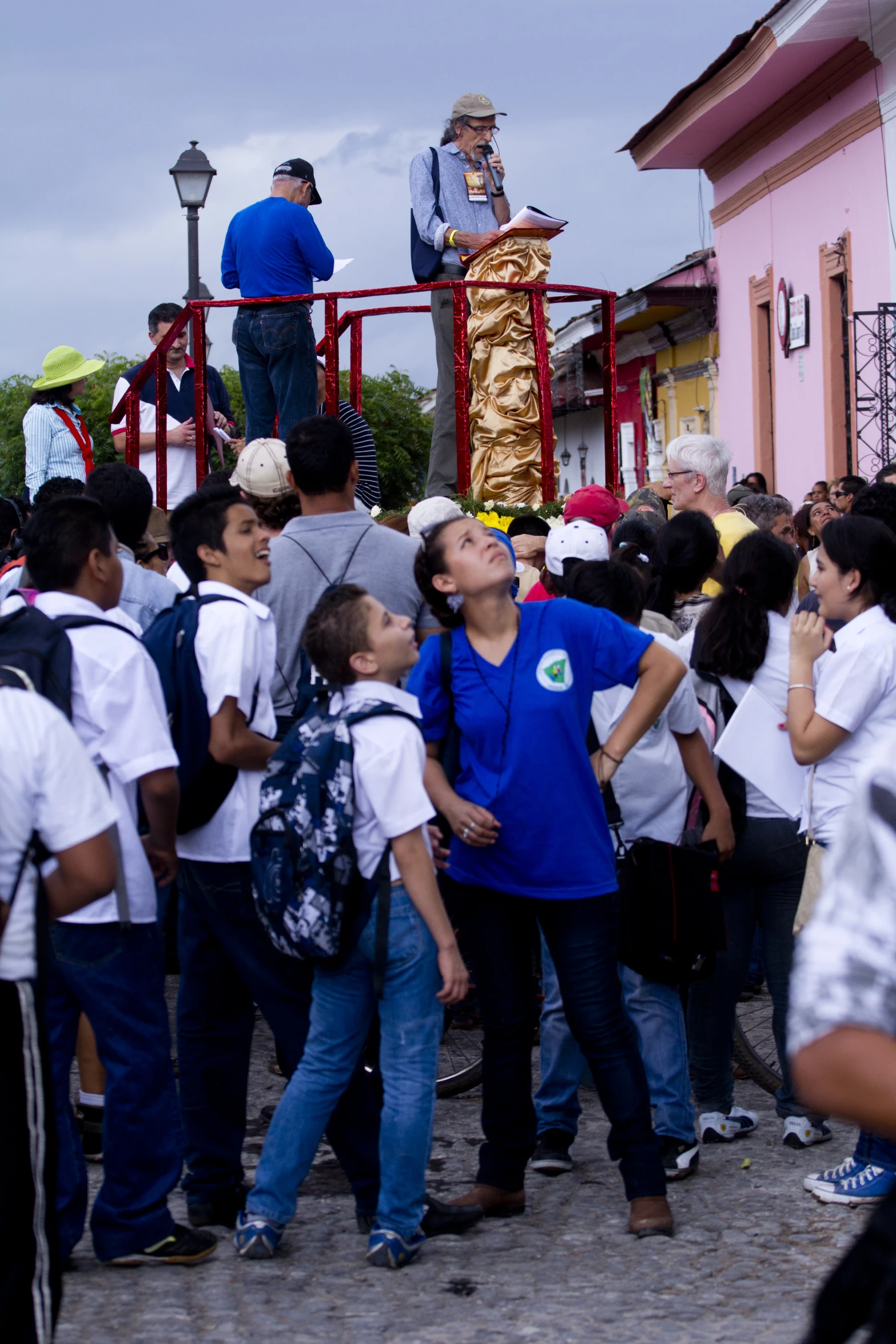 a crowd of people standing in front of a metal object