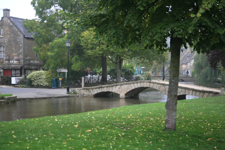 a bridge crosses over water in a park