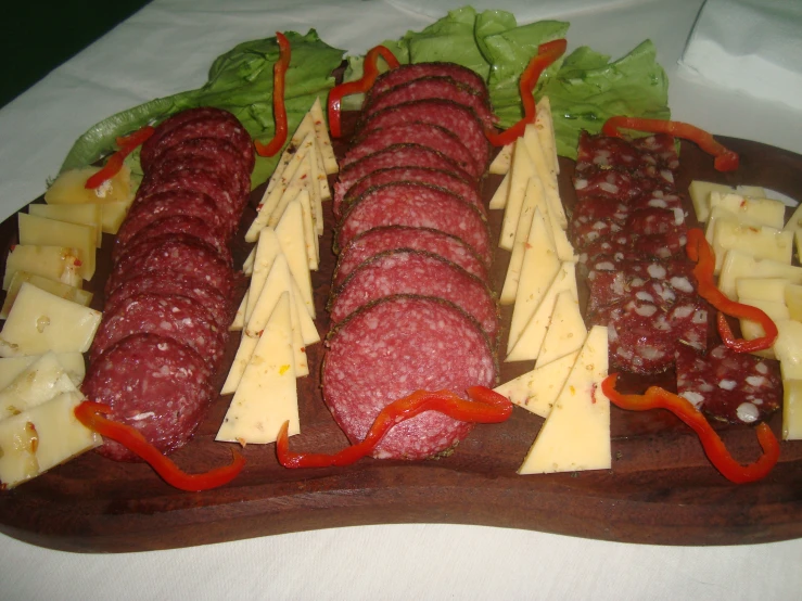 a long tray filled with meat, cheese and greens