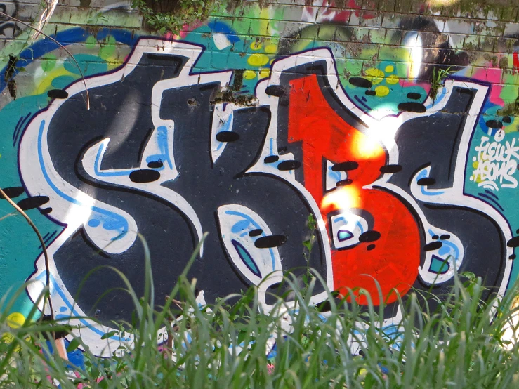the graffiti is multi - colored and black with orange and blue letters