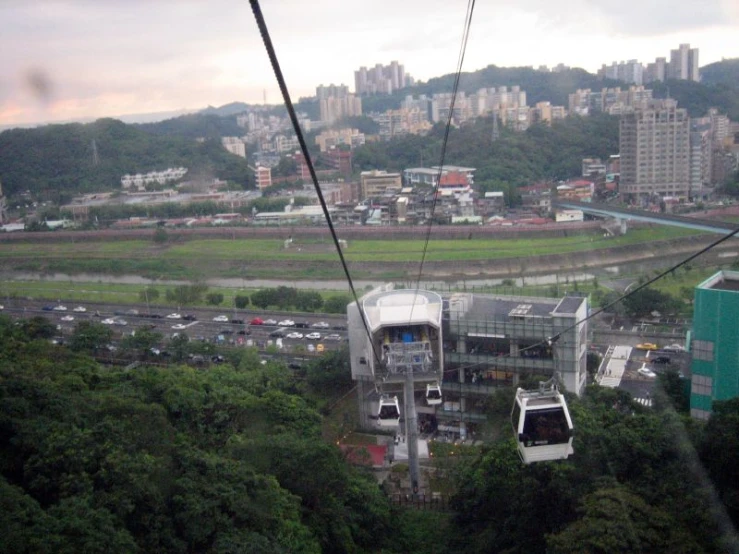 a cable car going over the mountain in front of a large city