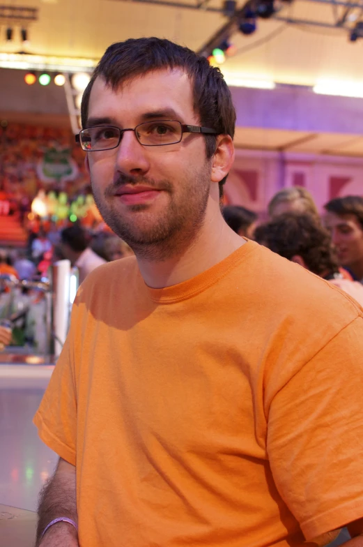 a man in an orange shirt in front of people
