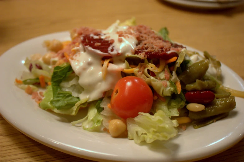 there is a white plate with vegetables and dressing on it