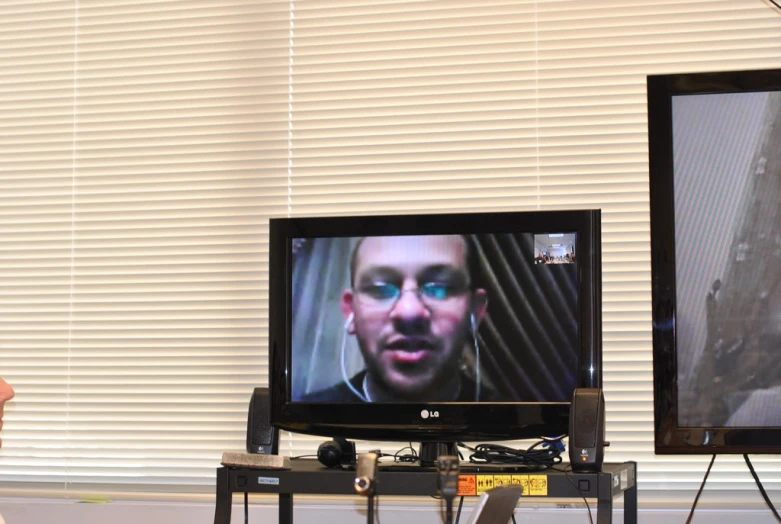 two monitors one on each side with a man staring into the screen