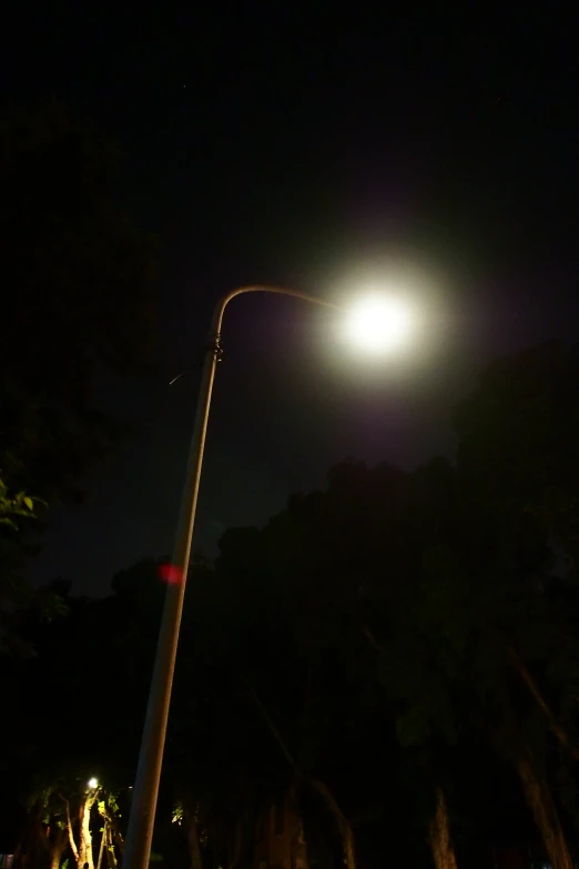 full moon in the night sky with street lamps