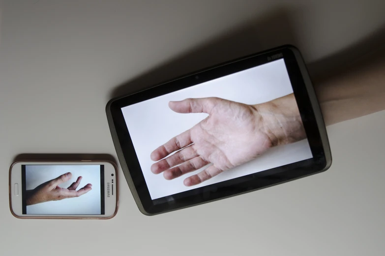 a hand is shown on an appliance next to another item