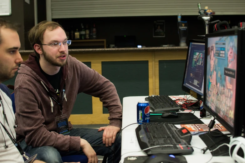 two men are at the computer and watching video games