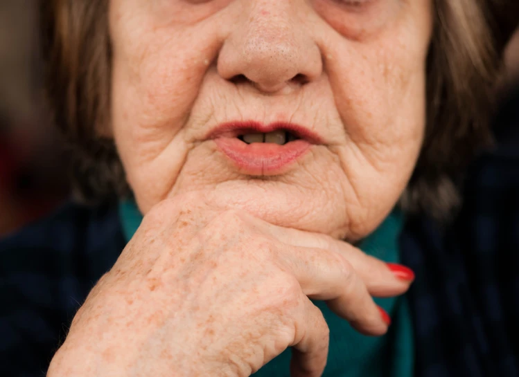 an older woman is making a face while looking off