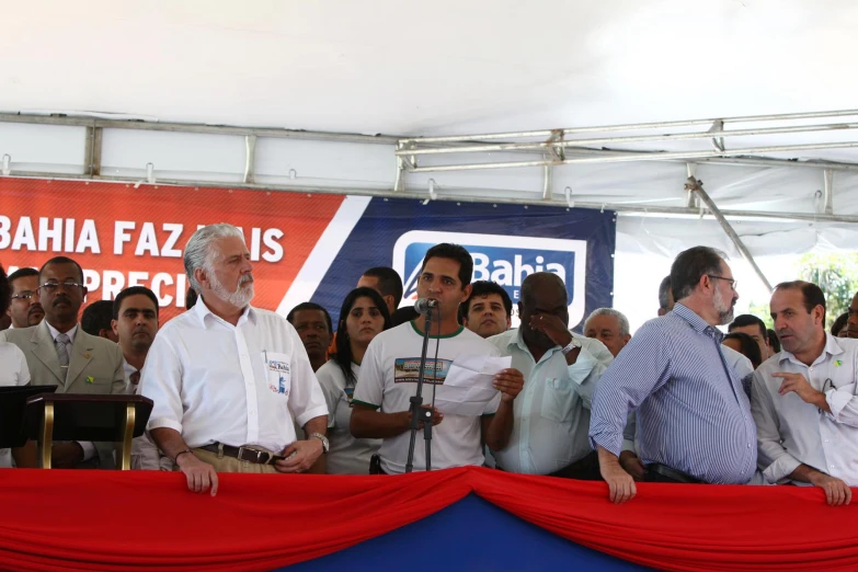 two men stand on a stage at a gathering