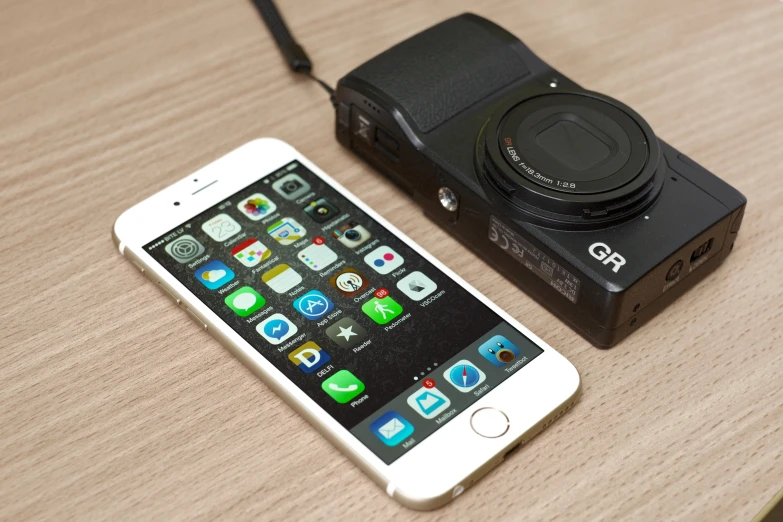 a camera and an iphone sitting on top of a table