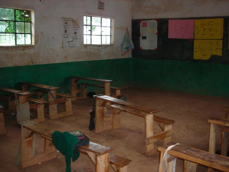 a school building with empty desks and an artist's easel