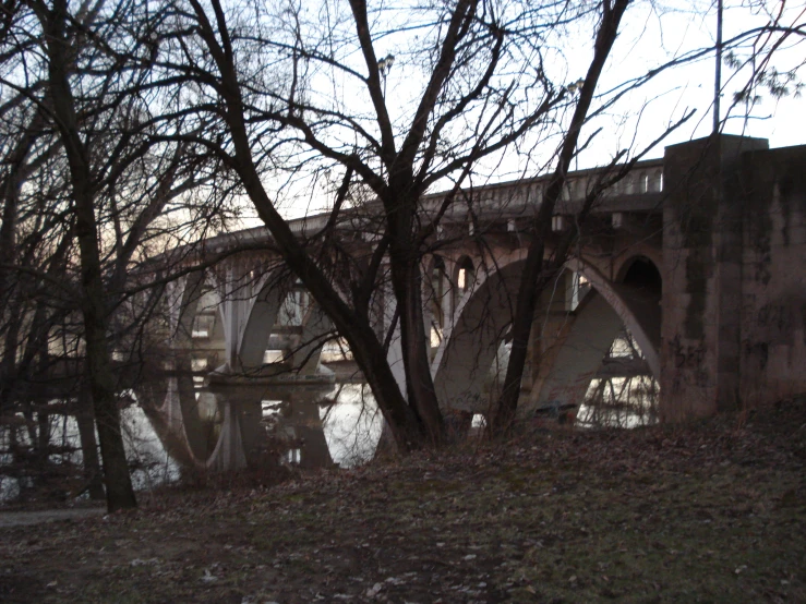 a bridge is shown over the water under trees