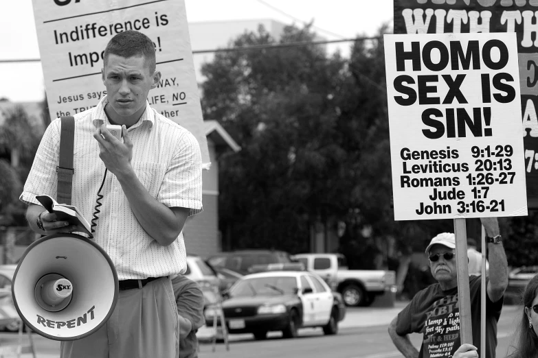 a man on a cell phone next to protest signs