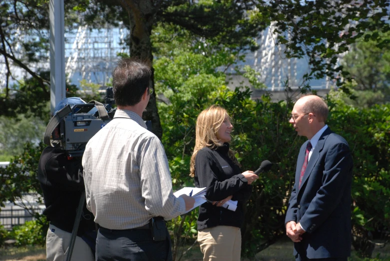 a man and woman talk to the media on the street