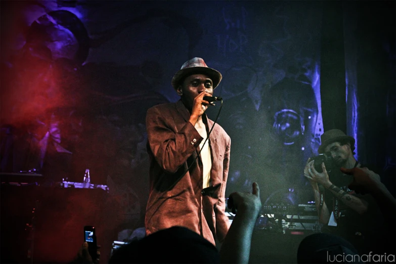 a man singing at a concert and holding up his hand