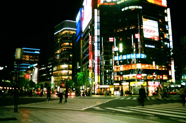 many people crossing at an intersection in the city