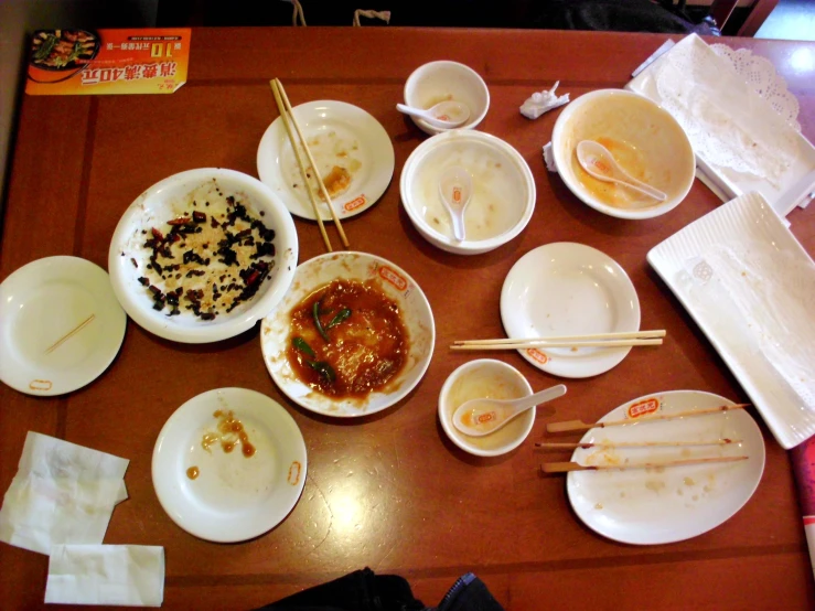 a table with various dishes and chopsticks on it