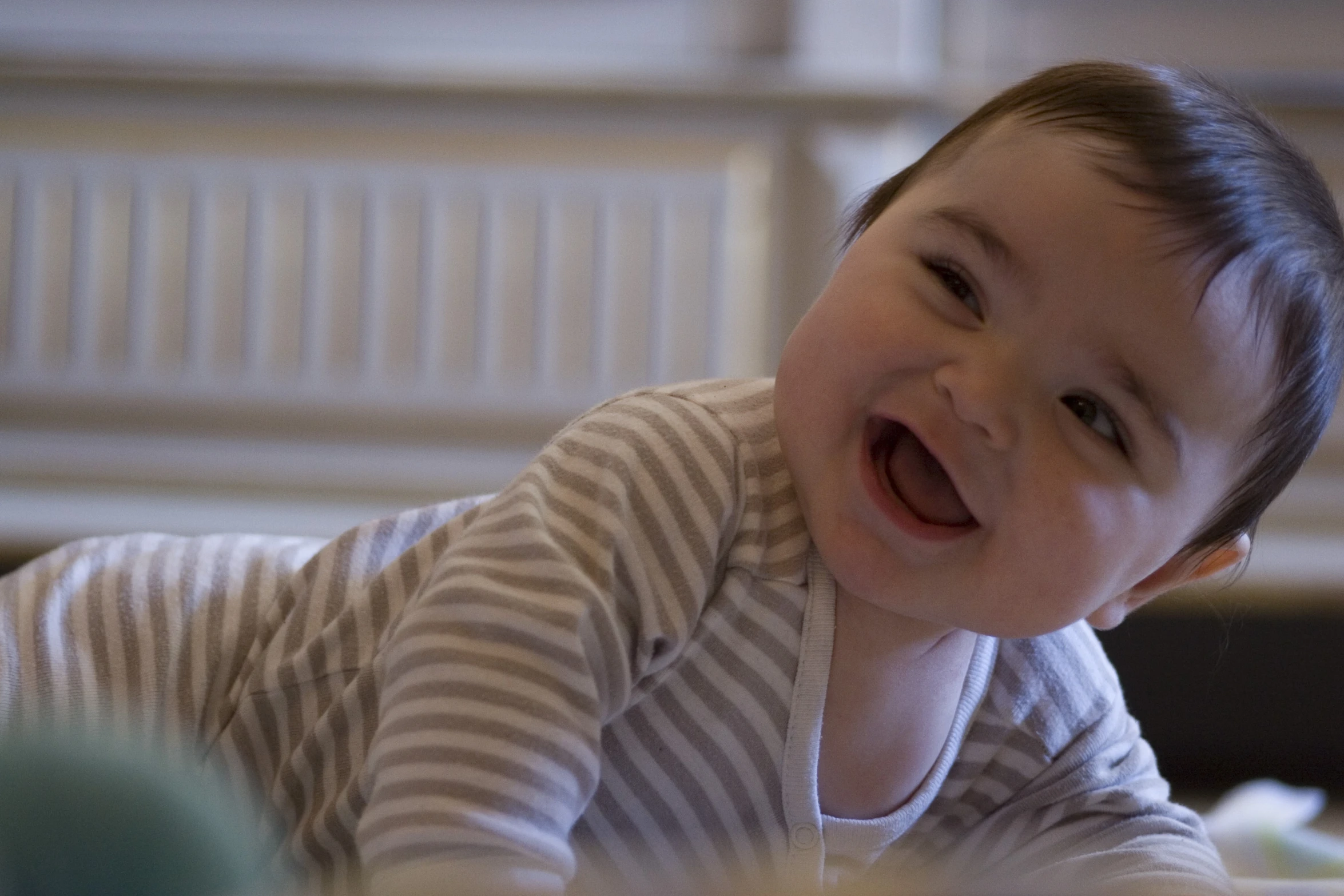 a young baby is smiling and laying on the bed