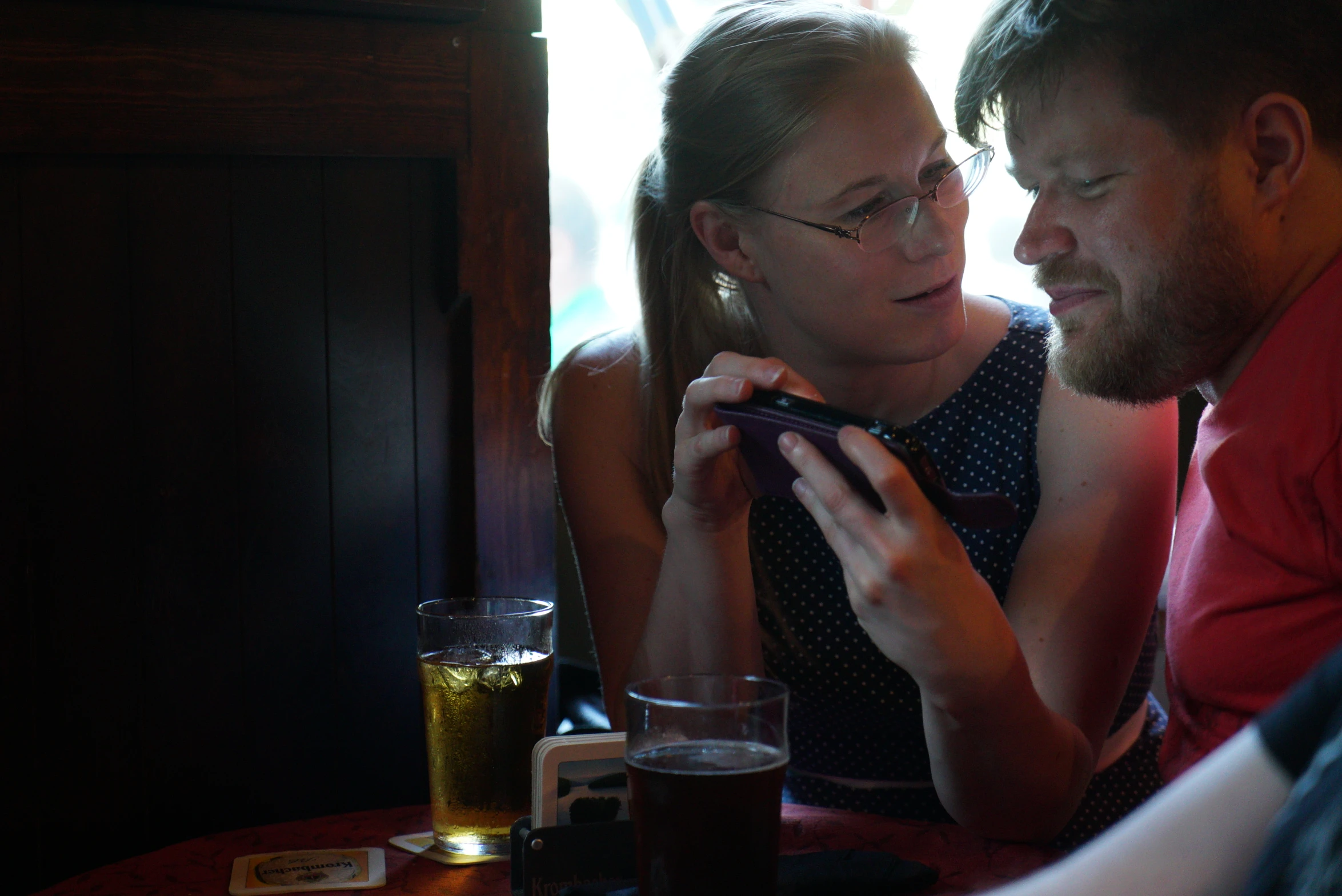 a man and a woman staring at soing on a cell phone