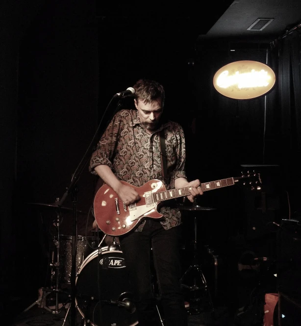 a man standing with an electric guitar in his hand