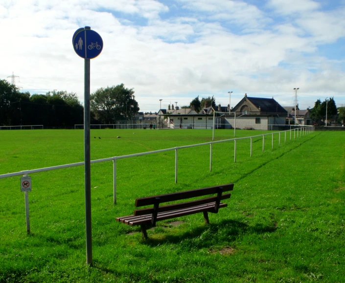 a park bench sitting in the middle of a green field