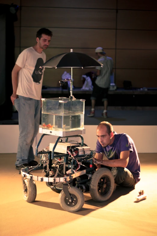 two guys looking at a camera with wheels attached