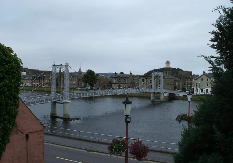 a small bridge over a river next to a town