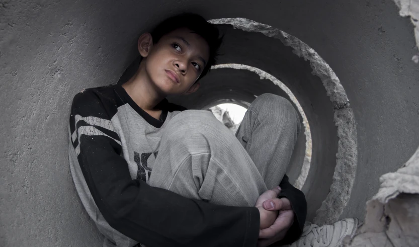 a man sitting inside of a cement bucket