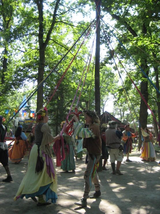 several people performing in the woods, all dressed up in traditional dress