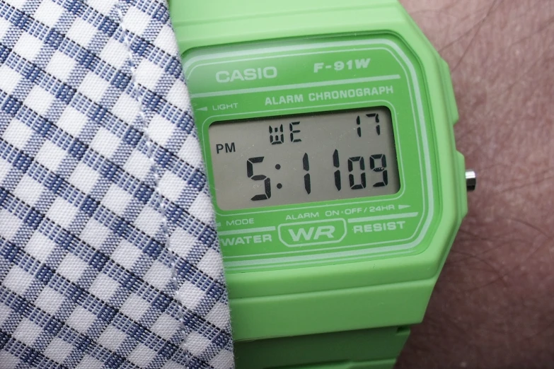 an electronic green clock on a man's wrist