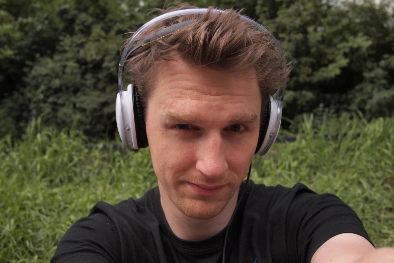 a man is wearing headphones looking at the camera