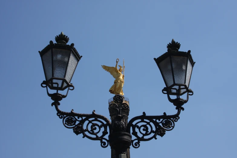 a street light with an angel statue on top