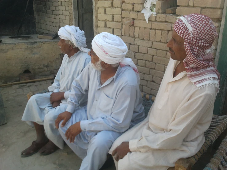 men in turbans are sitting on the bench